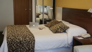 a hotel room with a bed with a laptop on it at Palm Beach Plaza Hotel in Montevideo