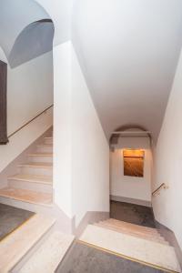 una scala con pareti bianche e un dipinto sul muro di Torre Argentina Relais - Residenze di Charme a Roma