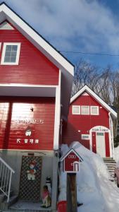 una casa rossa con una cassetta della posta rossa davanti di Cottage Morino Nakamatachi a Furano