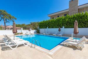 - une piscine avec des chaises longues et des parasols dans l'établissement Forest Park Hotel, à Kemer