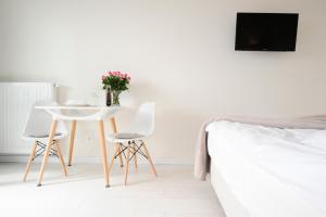 a bedroom with a table and two chairs and a bed at Romantic Sky Apartment- 15th floor in Kraków