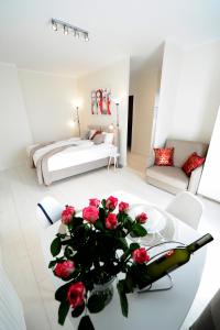 a living room with a table with roses on it at Romantic Sky Apartment- 15th floor in Kraków