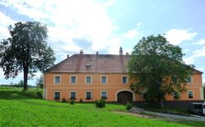 an orange house in a field with a tree at Statek Kloubek in Chabičovice