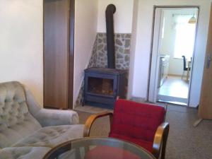 a living room with a fireplace and a red chair at Statek Kloubek in Chabičovice