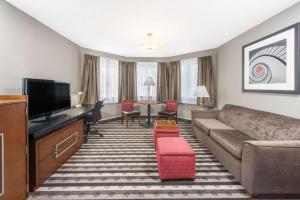 een woonkamer met een bank en een flatscreen-tv bij Ramada by Wyndham Springfield North in Springfield