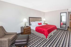 een hotelkamer met een bed en een bank bij Ramada by Wyndham Springfield North in Springfield