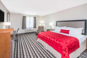 een hotelkamer met een rood bed en een televisie bij Ramada by Wyndham Springfield North in Springfield