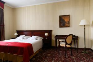 a hotel room with a bed and a desk and a chair at Turówka Hotel & Spa in Wieliczka