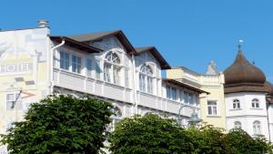 un vieux bâtiment avec une tourelle dans une rue de la ville dans l'établissement Hotel Deutsche Flagge, à Binz