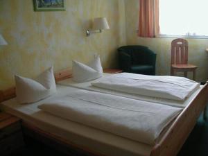 2 camas en un dormitorio con silla y ventana en Hotel Goldener Karpfen, en Aschaffenburg