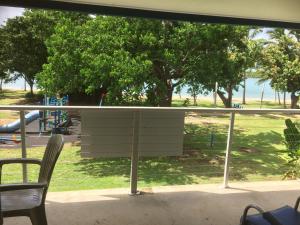 einen Balkon mit Blick auf einen Park mit Bäumen in der Unterkunft Whitehaven Beachfront Holiday Units in Airlie Beach