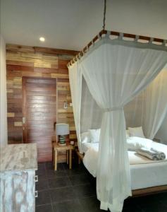 1 dormitorio con 2 camas y 1 cama con dosel en Blu d'aMare, en Gili Trawangan