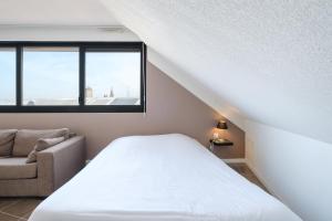 A bed or beds in a room at All Suites Appart Hôtel Dunkerque