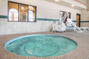 - une grande baignoire dans une pièce avec des chaises dans l'établissement Days Inn by Wyndham Carlsbad, à Carlsbad