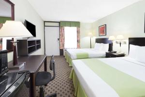 Tempat tidur dalam kamar di Days Inn by Wyndham Irving Grapevine DFW Airport North