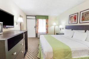 Tempat tidur dalam kamar di Days Inn by Wyndham Irving Grapevine DFW Airport North