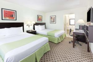 Tempat tidur dalam kamar di Days Inn by Wyndham Irving Grapevine DFW Airport North