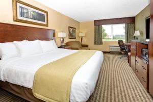 Cette chambre comprend un grand lit et un bureau. dans l'établissement Days Inn by Wyndham Cheyenne, à Cheyenne