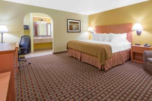 Cette chambre comprend un lit et un bureau. dans l'établissement Days Inn by Wyndham Lubbock South, à Lubbock