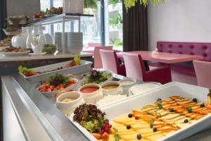 una linea a buffet con molti tipi di cibo diversi di Rija VEF Hotel with FREE Parking a Riga