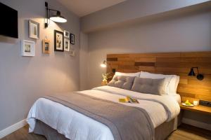 a bedroom with a large bed with a wooden headboard at Apollon Library Suites in Nafpaktos