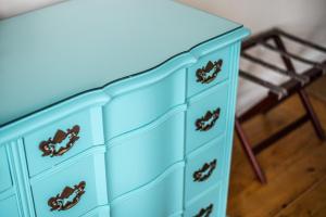 a blue dresser with a blue dresser with a stool at Salt Shaker Deli & Inn in Lunenburg