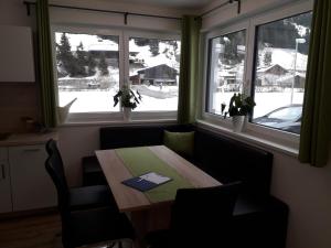 comedor con mesa y 2 ventanas en Apart Alpenflair, en Sankt Leonhard im Pitztal