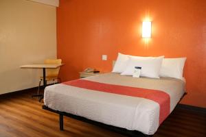 um quarto com uma cama grande e uma parede laranja em Motel 6-Warwick, RI - Providence Airport - I-95 em Warwick