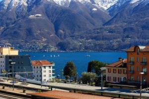 vista su una città con montagne e una cassa d'acqua di Hotel Rio Muralto a Locarno