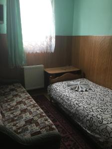 Cette petite chambre comprend 2 lits et une fenêtre. dans l'établissement Садиба Достаток, à Kolomya