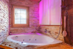 a bathroom with a white tub with pink lighting at Chalet Schtuba in Zermatt