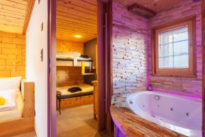 a bathroom with a tub and a bedroom with a bunk bed at Chalet Schtuba in Zermatt