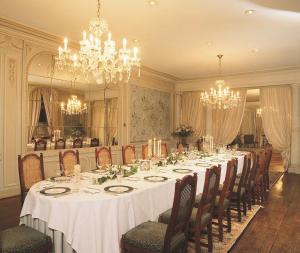 une salle à manger avec une grande table et des lustres dans l'établissement Chateau d'Hassonville, à Aye