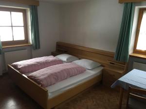 a bedroom with a bed with two pillows on it at Fallerhof in Villnoss