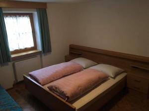 a bed with two pillows on it in a bedroom at Fallerhof in Villnoss