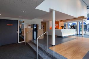 eine Bürolobby mit einer Treppe und einem Kühlschrank in der Unterkunft easyHotel The Hague Scheveningen Beach in Scheveningen