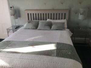 een slaapkamer met een groot bed met witte lakens en kussens bij Moraydale Guest House in Elgin