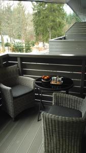 d'une terrasse avec 2 chaises et une table avec de la nourriture. dans l'établissement Harrachov Resident Apartments with Terrace, à Harrachov