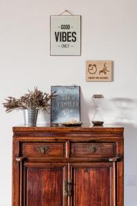 - une commode en bois dans une pièce avec des panneaux sur le mur dans l'établissement Eco Soul Ericeira Guesthouse - Adults Only, à Ericeira