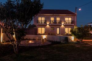 une maison avec des lumières devant elle la nuit dans l'établissement Eco Soul Ericeira Guesthouse - Adults Only, à Ericeira