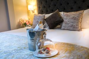 a table with a jar and a plate of food on a bed at Shipquay Boutique Hotel in Derry Londonderry