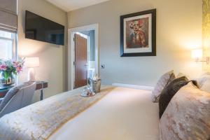 a bedroom with a bed and a desk and a television at Shipquay Boutique Hotel in Derry Londonderry