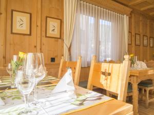 a dining room with a table with wine glasses at Hotel Alpina in Zernez