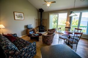 uma sala de estar com um sofá e uma mesa em Chalets Condos sur le Fjord em LʼAnse-Saint-Jean