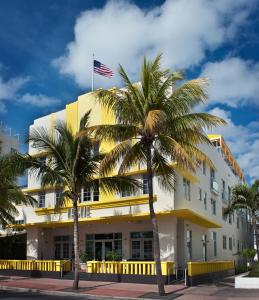 an american flag on top of a building with palm trees at Leslie Hotel Ocean Drive in Miami Beach