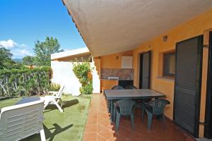 een patio met een tafel en stoelen in de achtertuin bij Residence Baia Salinedda in San Teodoro