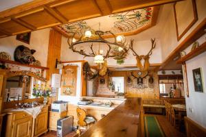 een keuken met een grote houten tafel en een kroonluchter bij Casa Cerbului1 in Sebeş