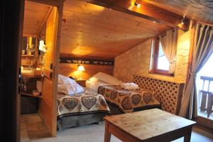 um quarto com duas camas e uma mesa num quarto em Hôtel Chalet Alpage em La Clusaz