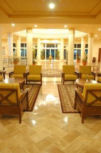 a lobby with tables and chairs in a building at El Mouradi Tozeur in Tozeur