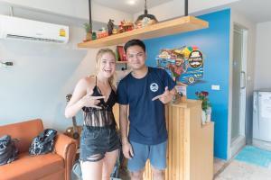 a man and a woman standing in a room at Hip Hostel - SHA Plus in Patong Beach